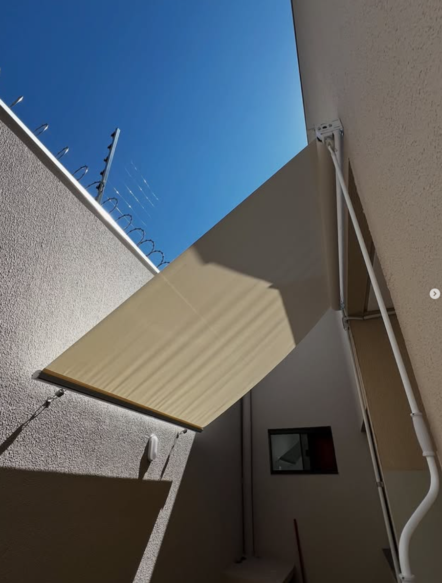 Toldo retrátil articulado instalado em área externa residencial